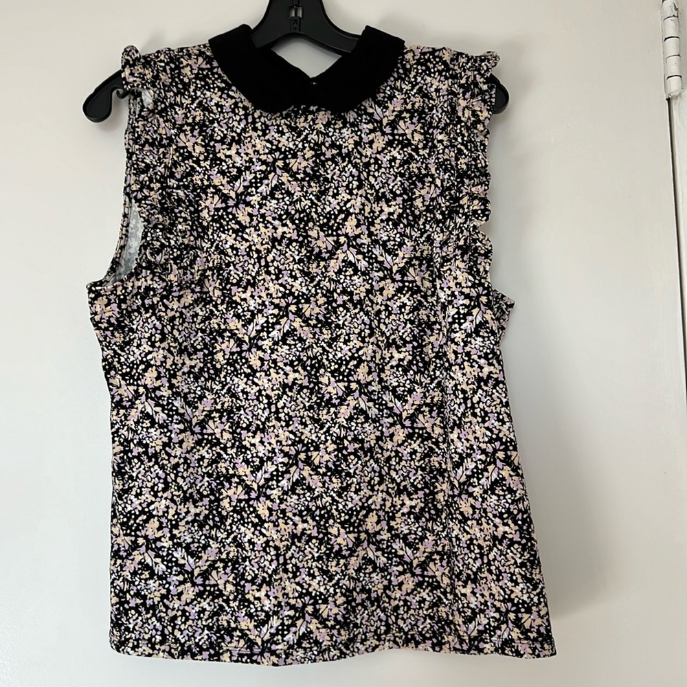 New. Women’s sleeveless top with ruffled arm openings.